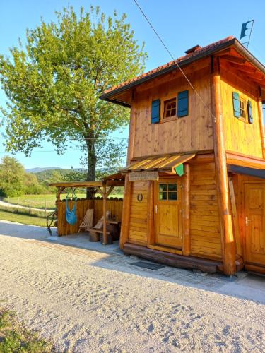 a log cabin with a porch and a house at Unique wooden holiday house in nature in Lukovica pri Domžalah