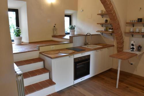 uma cozinha com armários brancos e uma escadaria em Claves Claustri - Camere in appartamento storico em Sarteano