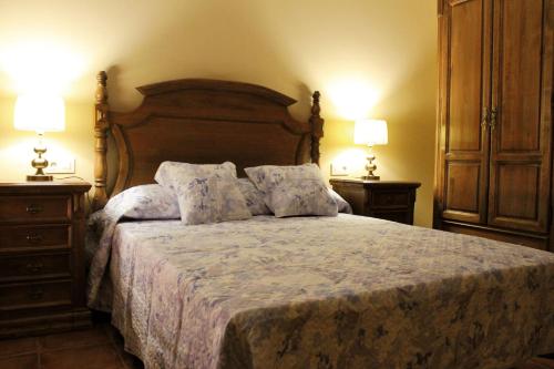 a bedroom with a bed with two night stands and two lamps at Señorio de Quevedo in Villanueva de los Infantes