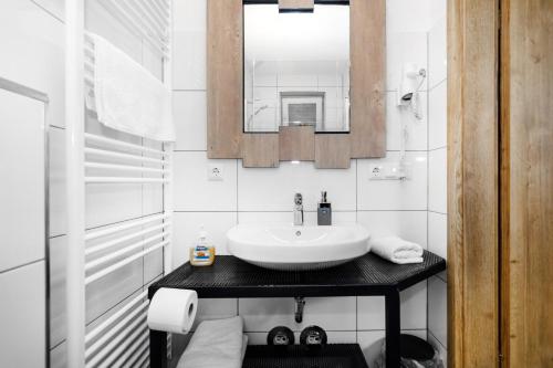 uma casa de banho branca com um lavatório e um espelho em D & D Weserpension 
