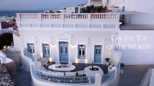 a white building with the words on the top of the world at Oia Mansion in Oia