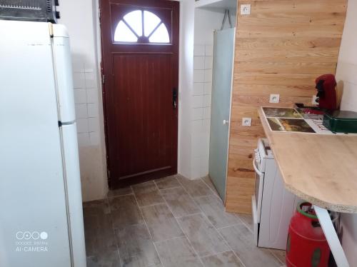 cocina con puerta de madera y barra en Chambre à petit budget pour personne simple, en Saint-Laurent-de-Neste