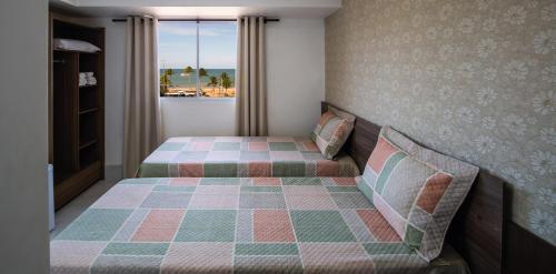 a bedroom with a bed and a window at Tambau Beach Hotel in João Pessoa