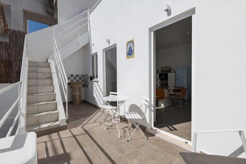 a house with a staircase and a table and chairs at Casa Largo da Mó in Portimão