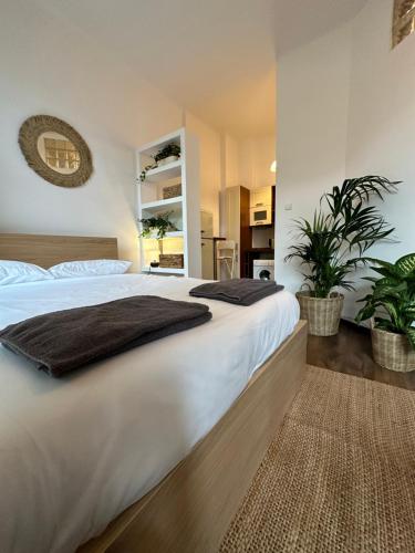 een slaapkamer met een groot wit bed en 2 planten bij Studio na Starej Ochocie in Warschau