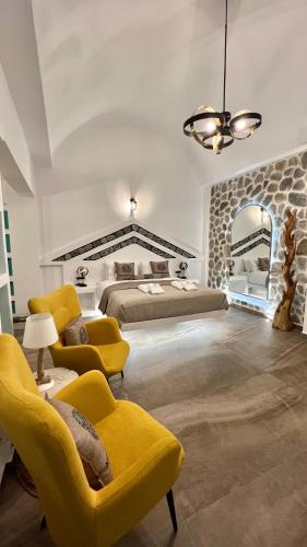 a large bedroom with two beds and two chairs at Anastasia Princess Luxury Beach Residence, Adults Only in Perissa