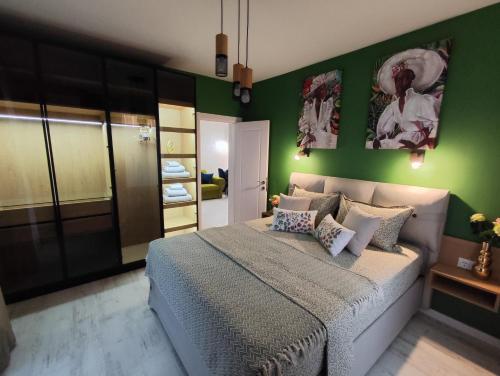 a bedroom with green walls and a large bed at Аpartment Bella Vista in Obzor