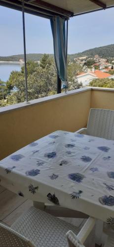 a table and chairs on a balcony with a view at APARTMANI SENKA - VILLA OLIVER in Martinšćica