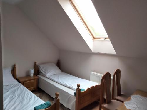 a bedroom with two beds and a skylight at Przy Trójstyku in Dubeninki