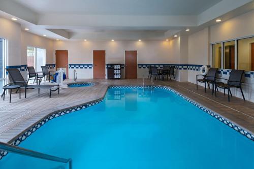 einen Pool in einem Zimmer mit Stühlen und Tischen in der Unterkunft Fairfield Inn and Suites by Marriott McAllen in McAllen