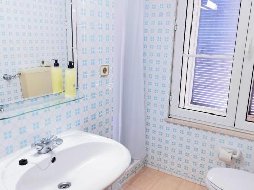 uma casa de banho com um lavatório branco e um WC. em Garden's Nest - North Villa em Conceição