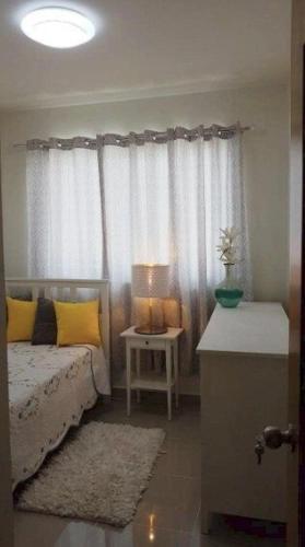 a bedroom with a bed and a table with a lamp at Moderno Apartamento amueblado Full 3 habitaciones, wifi, Netflix in Santiago de los Caballeros