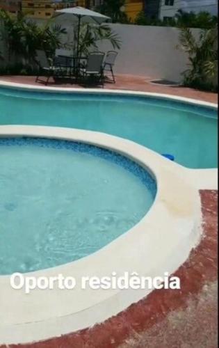 a large blue swimming pool with an umbrella at Moderno Apartamento amueblado Full 3 habitaciones, wifi, Netflix in Santiago de los Caballeros