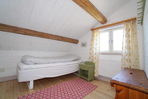 Habitación pequeña con cama y ventana en Mittjas Vallen Timber Lodge & Cabins, en Edsbyn