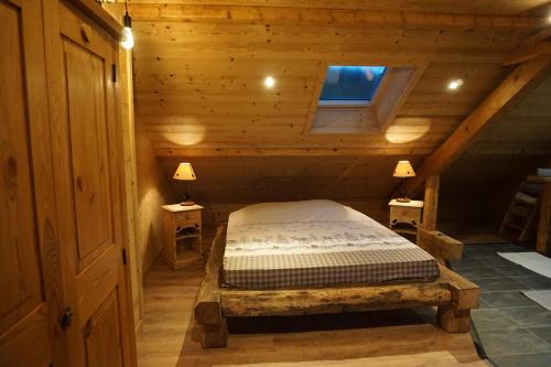 um quarto com uma cama num chalé de madeira em Le chamois, chez le charpentier d'antan, au calme, spacieux T3 duplex, ambiance chalet, vue dégagée, parking privé em Épagny