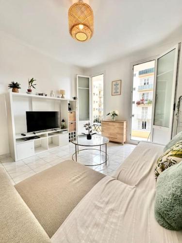 un salon avec un canapé et une table dans l'établissement Cosy apartment - 15 min from beach - Free Parking, à Nice