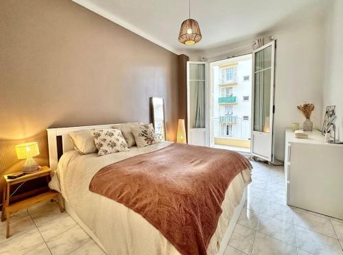 une chambre avec un lit et une grande fenêtre dans l'établissement Cosy apartment - 15 min from beach - Free Parking, à Nice