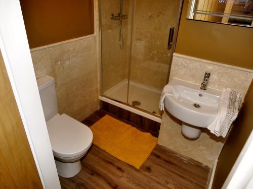 a bathroom with a toilet and a sink and a shower at Ultra Deluxe Versace Apartment Near Sheffield FULL SKY TV in Rotherham