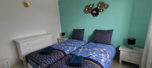 a bedroom with a bed with a blue wall at Libenliny in Durbuy