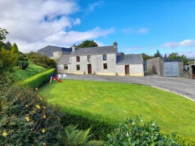 una casa en un patio de césped con una casa en 4 Bedroom Traditional Irish Farm House Killybegs en Donegal