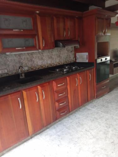 uma cozinha com armários de madeira e um forno com placa de fogão em Apartamento Duplex em Medellín