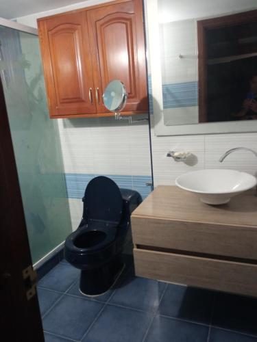 uma casa de banho com um WC preto e um lavatório. em Apartamento Duplex em Medellín