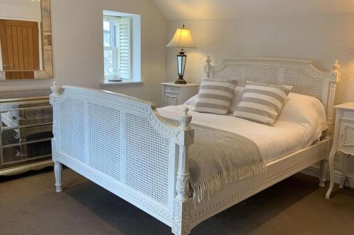 a bedroom with a white bed with pillows at Folly Farm Cottage, Cosy, Secluded near to St Ives in St Ives