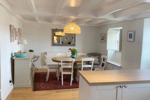 a kitchen and dining room with a table and chairs at Folly Farm Cottage, Cosy, Secluded near to St Ives in St Ives