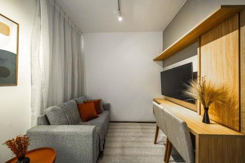 uma sala de estar com um sofá e uma televisão em Tabas - Edifício Studio In - Brasília em Brasília