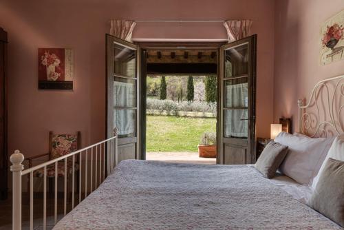 a bedroom with a large bed and an open door at Agriturismo Nobile in Montepulciano