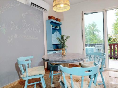 a dining room with a blue table and chairs at HangVilla Badacsony in Badacsonytomaj