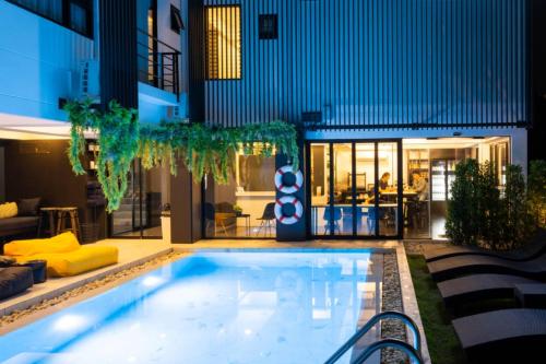 a large swimming pool in front of a building at Asa Hotel in Chiang Mai