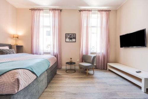 a bedroom with a bed and a flat screen tv at Entspannen in unserer gemütlichen Suite A in Bad Camberg