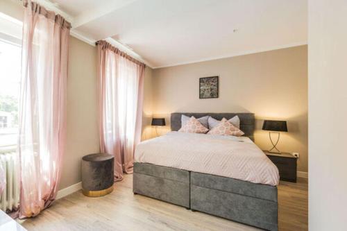 a bedroom with a large bed with pink curtains at Entspannen in unserer gemütlichen Suite A in Bad Camberg