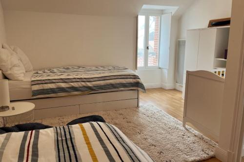 une chambre blanche avec un lit et une table dans l'établissement Maison de Ville, Hyper Centre, 8p, 105m2, à Pornic