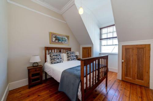 a bedroom with a large bed and a window at 'Imagine' - Surfers Corner Muizenberg Village in Cape Town