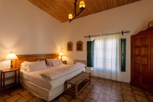 Un dormitorio con una cama grande y una ventana en Hotel El Manantial del Silencio en Purmamarca