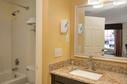 W łazience znajduje się umywalka i lustro. w obiekcie Super 8 by Wyndham Garner/Clayton/Raleigh w mieście Garner