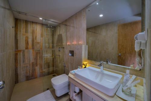 e bagno con lavandino, servizi igienici e doccia. di Hotel Barahi Pokhara a Pokhara