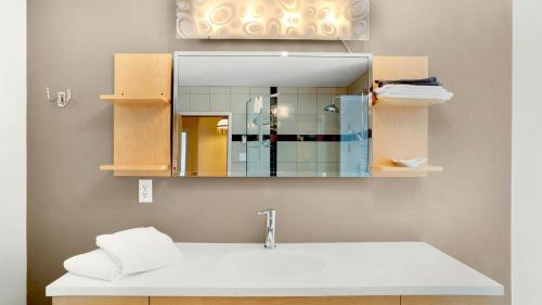 een badkamer met een wastafel en een spiegel bij Homeport Motel in Lunenburg