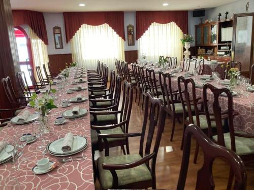 a long dining room with a long table and chairs at Hotel Leyton in Foz