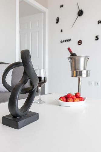 a black sculpture sitting on a counter with a glass of wine at Z5 Sky Sparta Apartment in Sparti