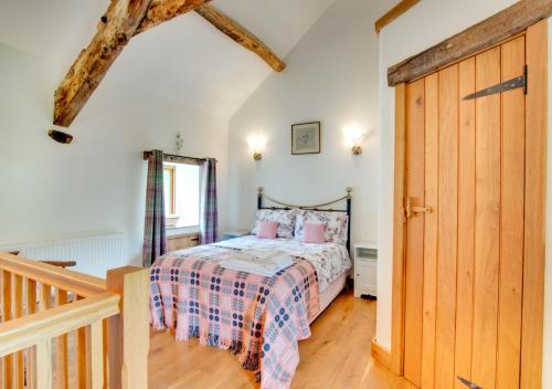 a bedroom with a bed and a wooden door at Crud y Wennol in Llandderfel