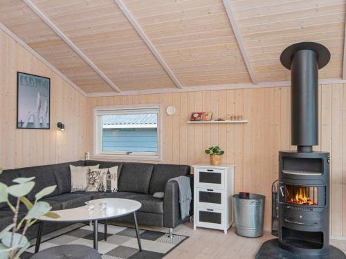 a living room with a couch and a wood stove at 6 person holiday home in Hemmet in Falen