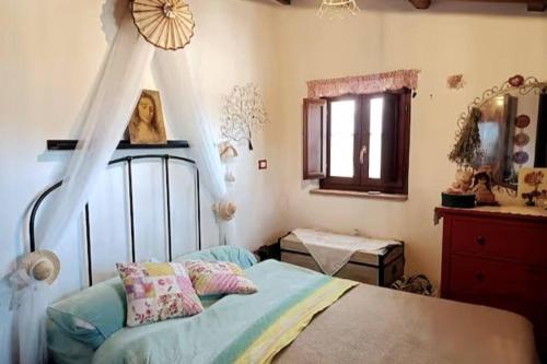 a bedroom with a bed and a dresser and a window at La casa della Rocca 