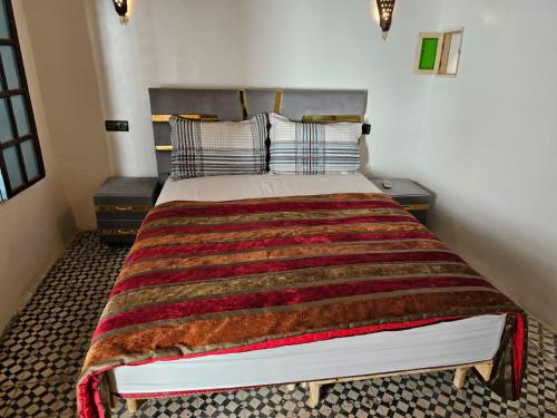 a bedroom with a large bed with a blanket on it at Riad Ali Baba Fes in Fez