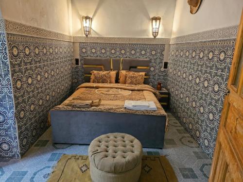 a bedroom with a bed with blue and white tiles at Riad Ali Baba Fes in Fez