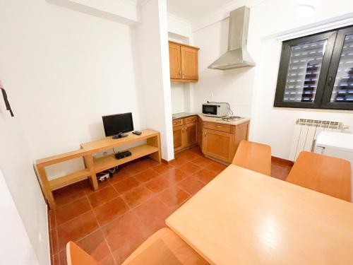 a kitchen with a table and a desk with a television at HI Areia Branca - Pousada de Juventude in Areia Branca