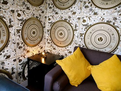 a room with a couch and a wall with plates at Stunningly Opulent Gold Apartment Near Sheffield FULL SKY TV in Rotherham