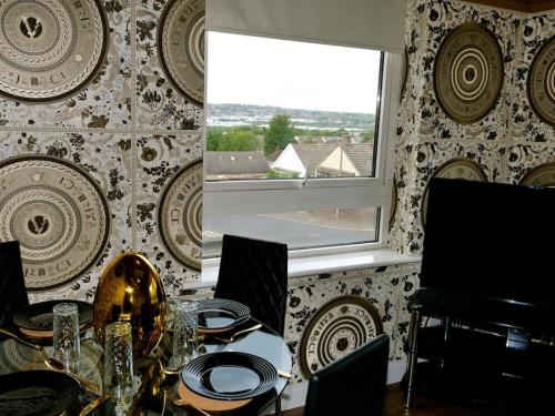 a dining room with a table and a window at Stunningly Opulent Gold Apartment Near Sheffield FULL SKY TV in Rotherham